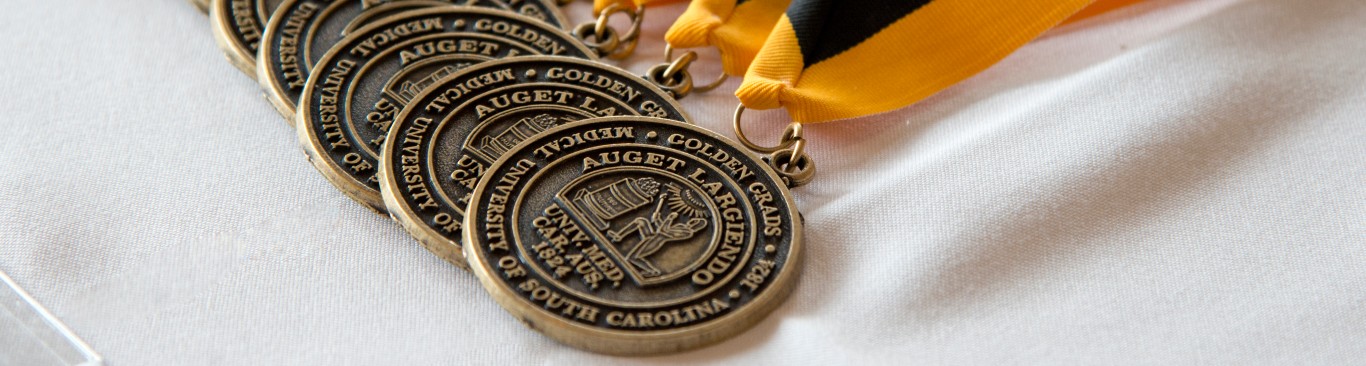 Golden Grad medallions displayed on a table.