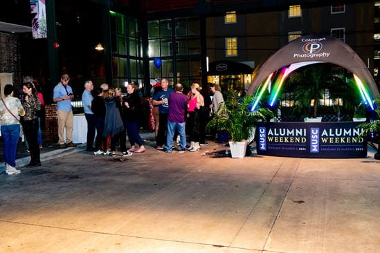 Last year's Alumni Weekend Bash attendees line up outside of the 360-photo booth to create a video commemorating the event.