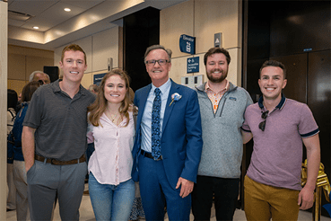  Four orthodontics residents stand smiling with Dr. Boyd at the celebration of the new lobby. 
