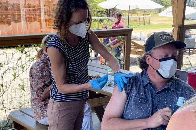 Estee Perlmutter ’06 administers the Pfizer COVID vaccine during a community event in spring 2021.