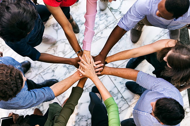 Group of diverse people with their hands put into a circle