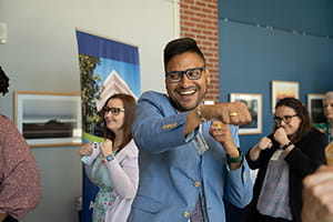 Ronnie Chatterjee air punching in hallway of educational building