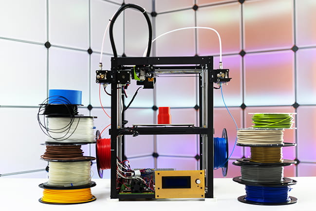 3d printer and plastic filament on color background