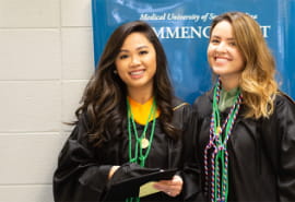 Two smiling graduates