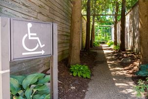 ADA compliance sign pointing to a handicap accessible pathway