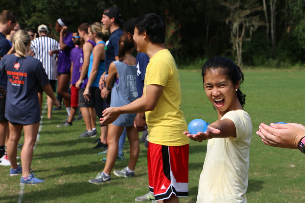 A young woman shows off a water balloon at a field day event 