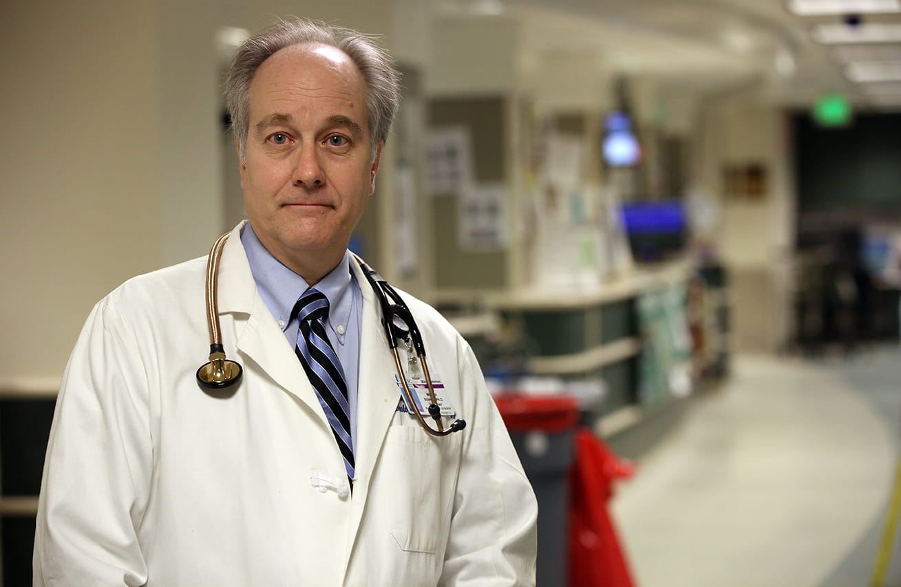 Dr. Michael Schmidt wearing lab coat and stethoscope and standing in hospital