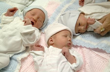 Newborn triplets lying on a blanket