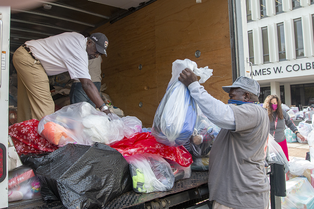 Two men load the Salvation Army's truck with bags of gifts.